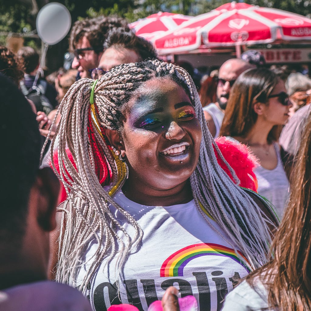 A woman looks off into the distance in a crowd of people.