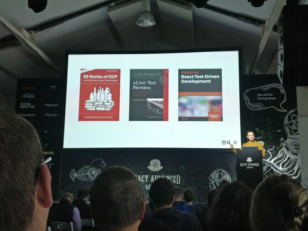 David Irvine on stage with a selection of his books on a slide