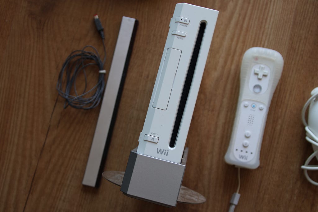 Birdseye view of a white Nintendo Wii system with a Wiimote and a sensor bar