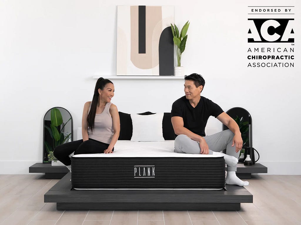 Couple sitting on Plank firm mattress