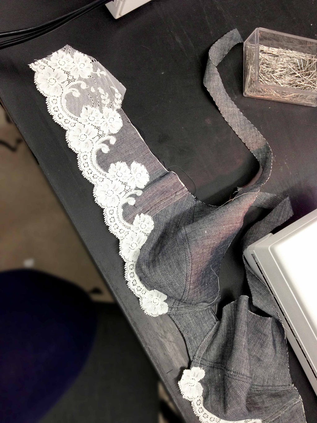 Birdseye view of a denim bra with lace being constructed