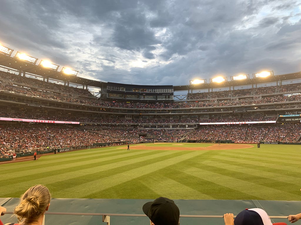 A baseball stadium at dusk filled with fans
