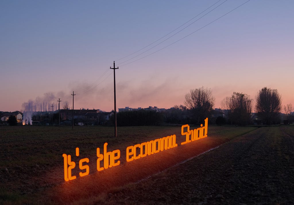 Neon sign reading, “It’s the economy, Stupid.”