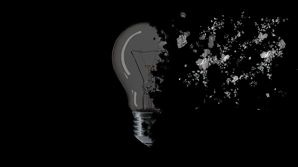 A broken lightbulb on a black background