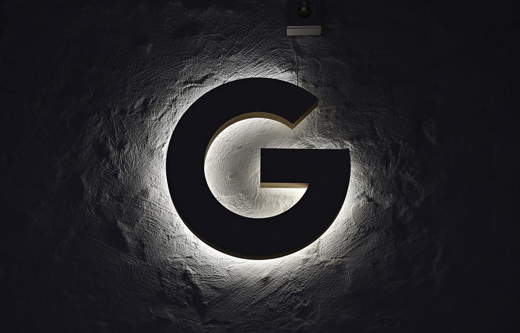 An illuminated “G” hangs on the wall.