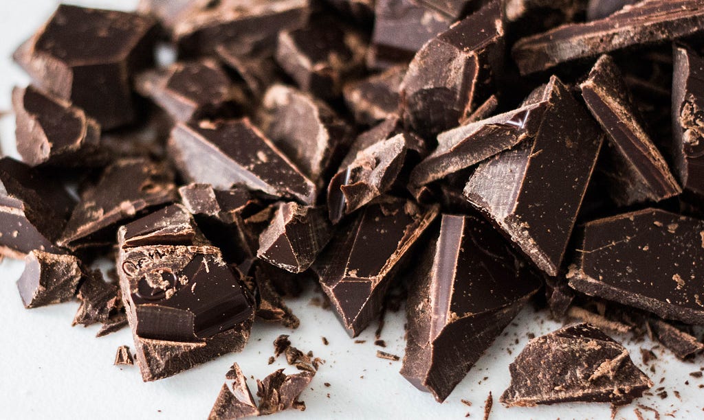 A close up of cut up chocolate on a white table.