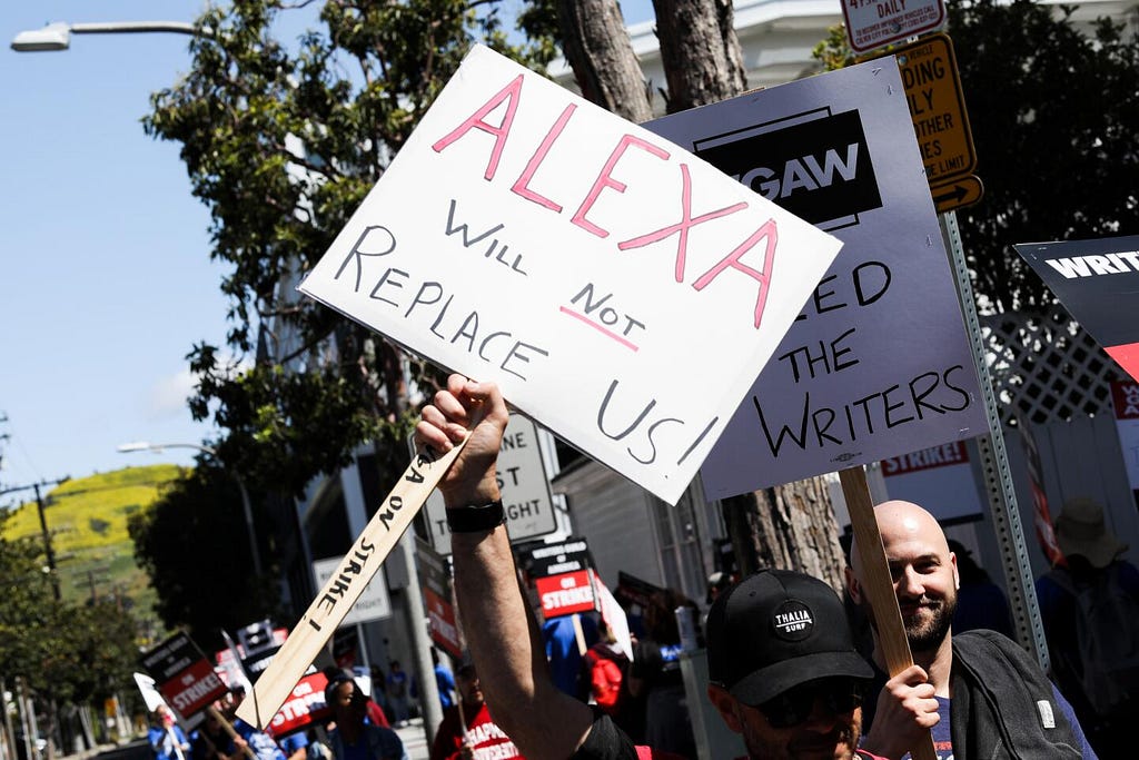 WGA striker holding up sign saying “Alexa will not replace us!”