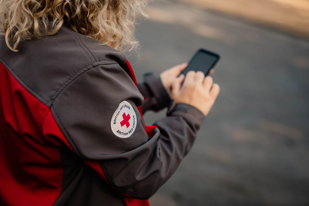 British Red Cross Volunteer checking their mobile phone