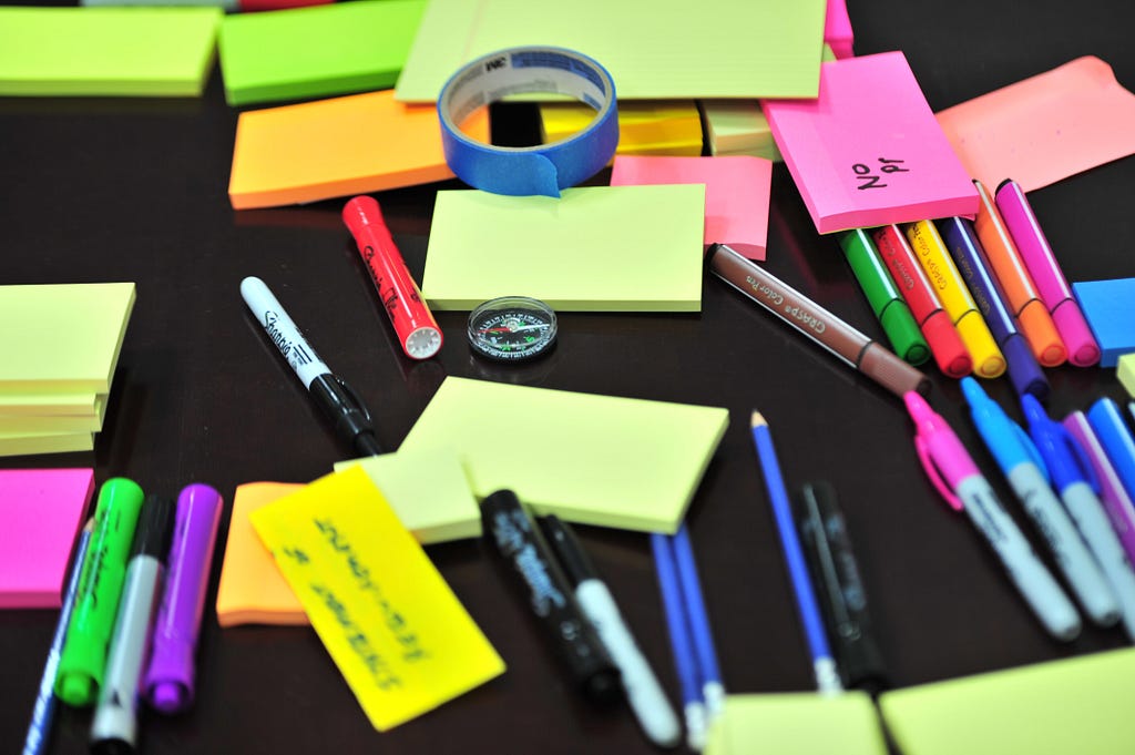 Post its and pens on a table.