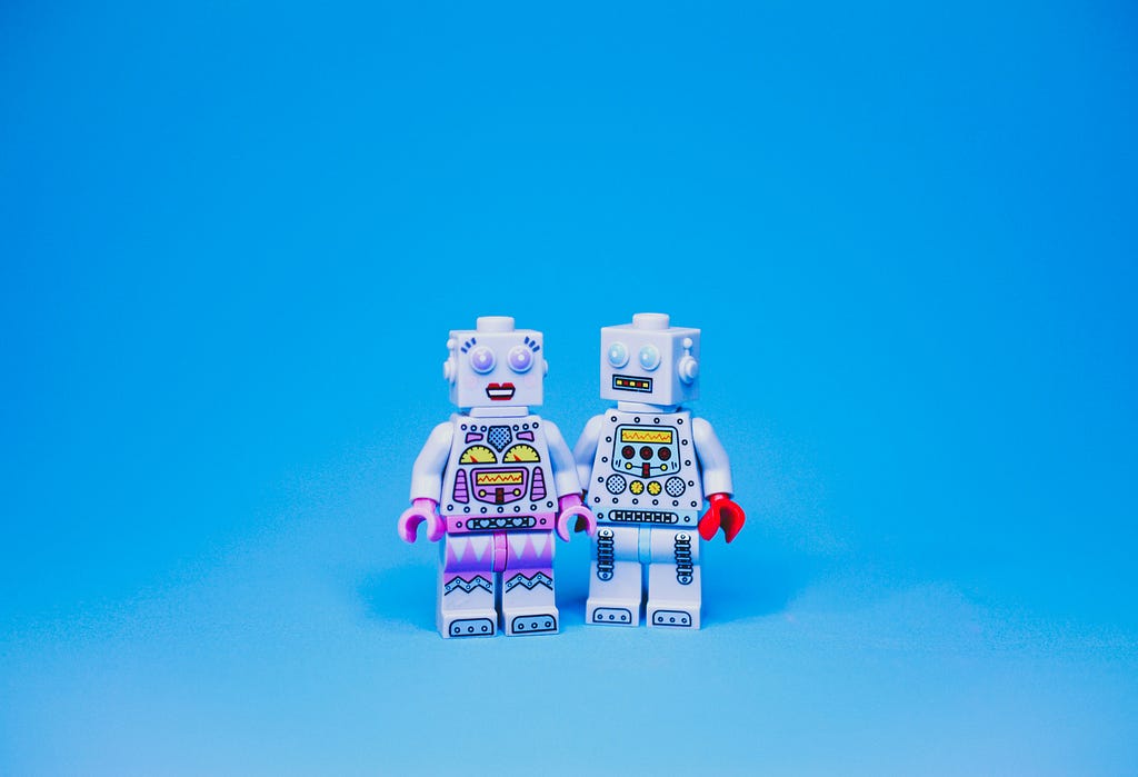 Two lego robot minifigs holding hands