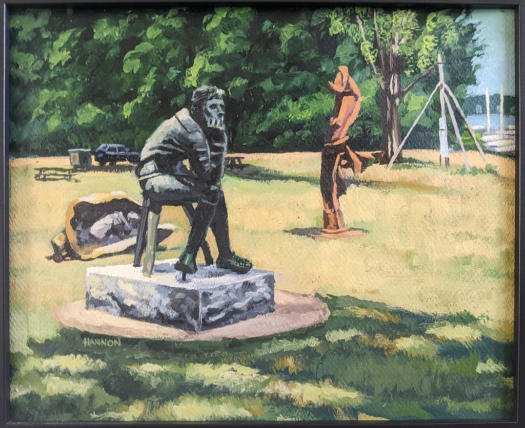 An open field with two sculptures shown. On the left is a seated figure on a rectangulat stone base. On the right is a modern sculpture made from twisted steel girders.