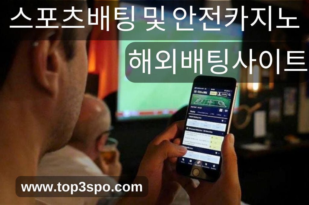 Man is betting in his phone while watching the game.
