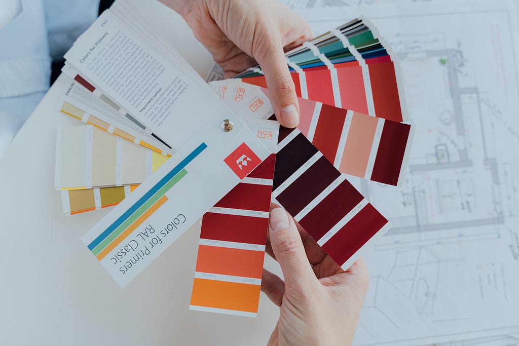 A person holding color palettes.