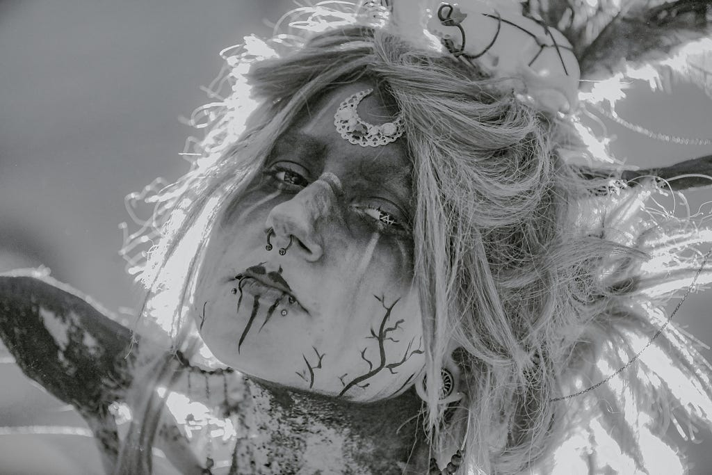 Black and white photo of tattooed, pierced face.