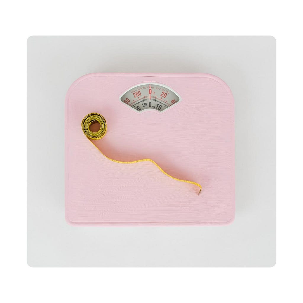 Picture of a pink scale with a yellow measuring tape on top.