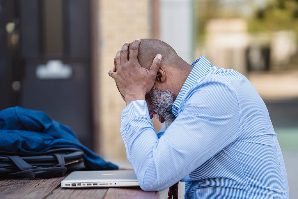 an entrepreneur holding his head and looking troubled