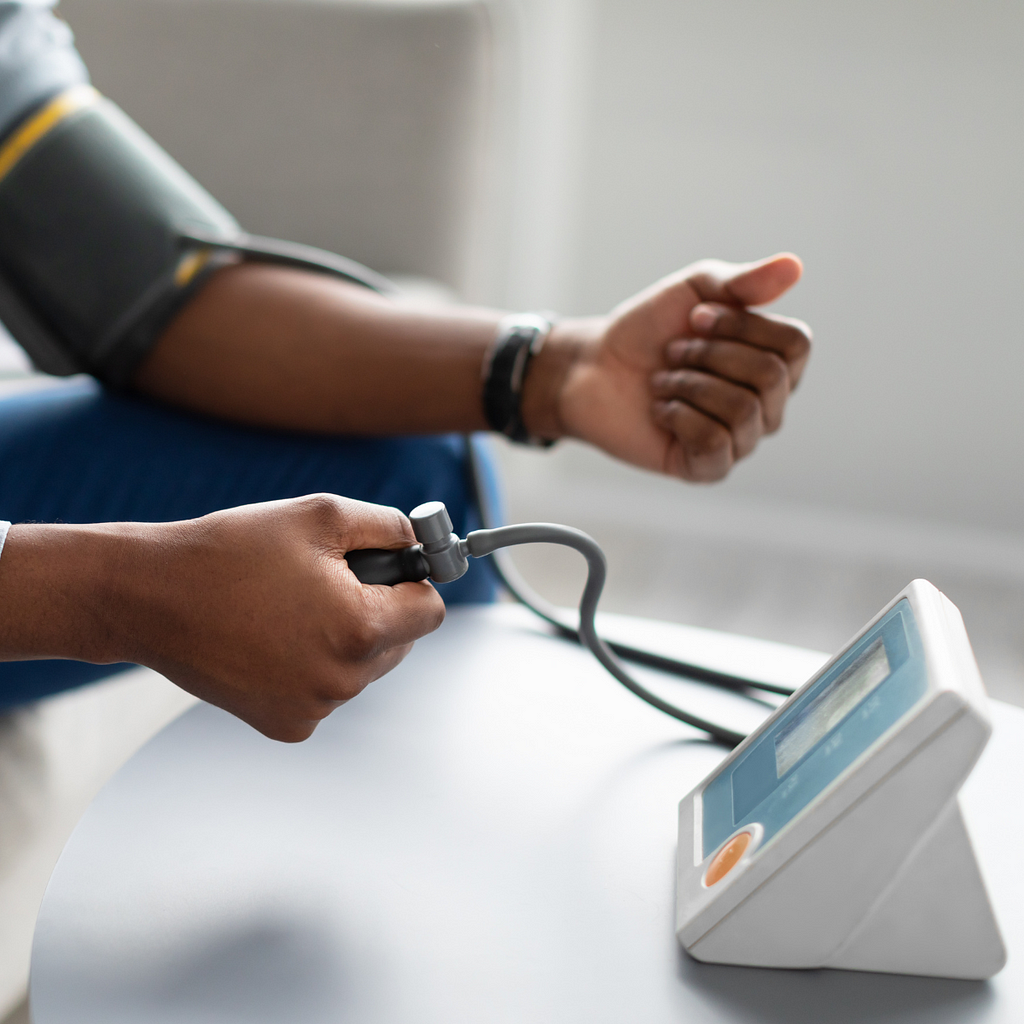 An individual checking their blood pressure with a traditional cuff.