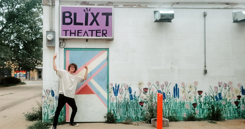 Jaevyn points toward the Blixt Theatre sign