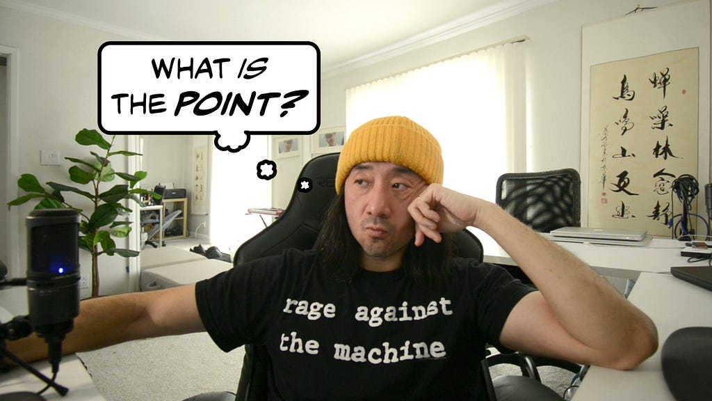 A man wearing a “Rage Against the Machine” t-shirt sits and looks to the side; a thought-bubble next to him reads, “What is the point?”