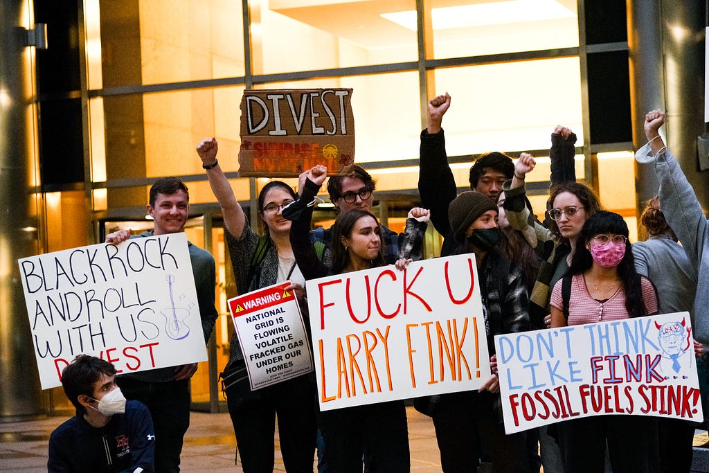 Students hold signs outside of Blackrock HQ