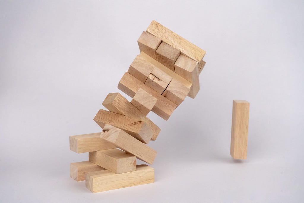 A Jenga tower in the midst of toppling over.