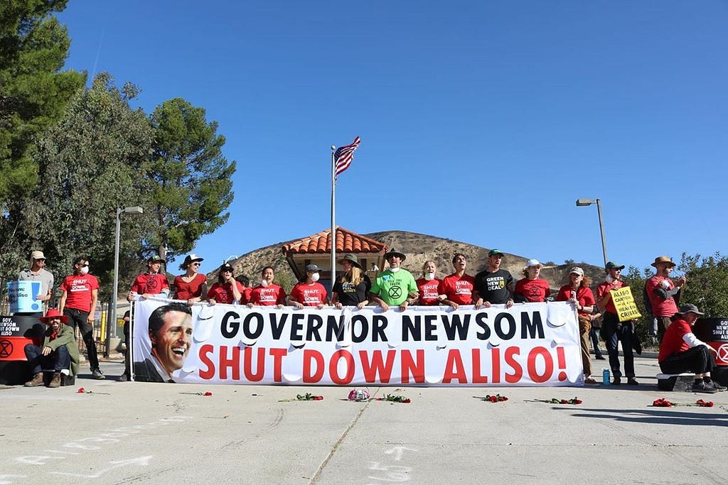 Protesters hold a banner saying: Governor Newson Shut Down Aliso!