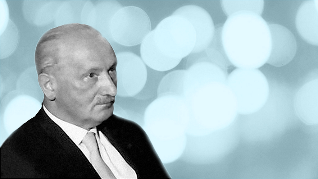 A portrait of Martin Heidegger against a background of blurry light spots.