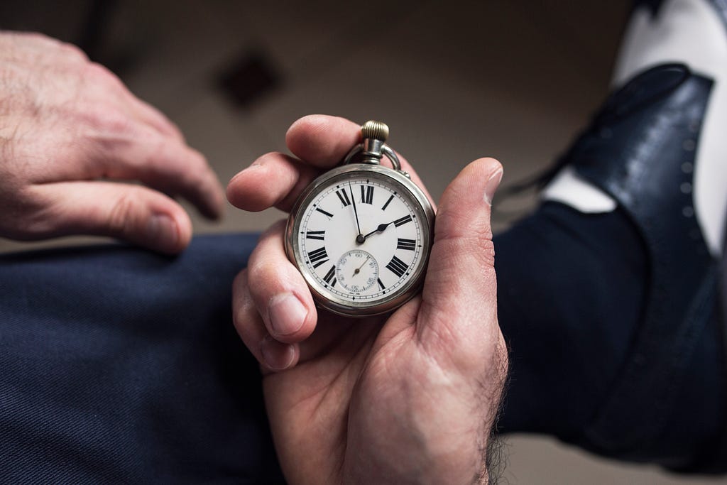 man’s hands holding a stopwatch