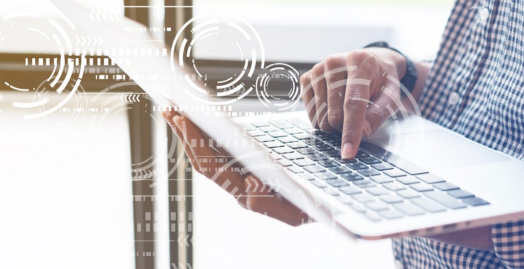 Close up photo of the hands of a programmer typing on laptop keyboard.