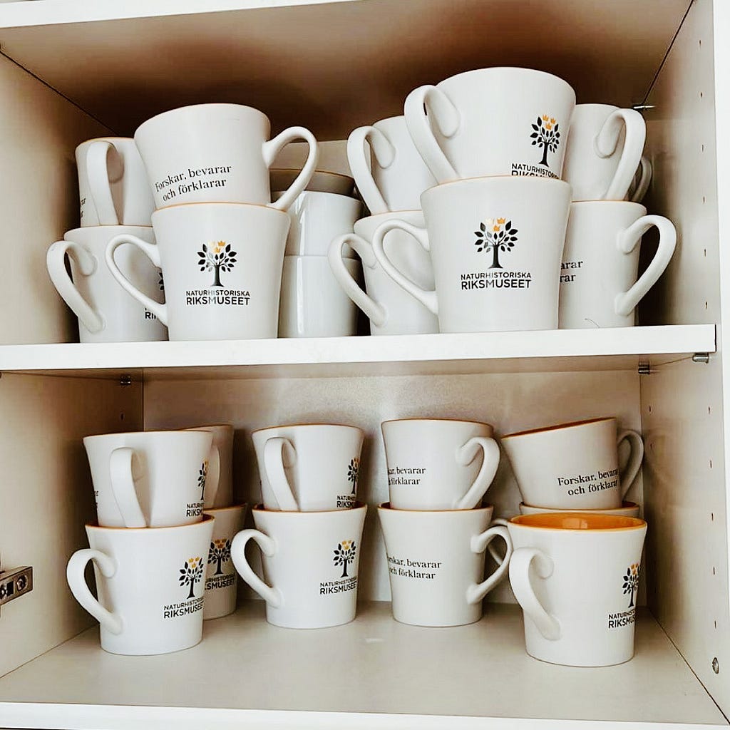 Collection of coffee mugs all featuring the new logo of the Swedish Museum of Natural History.