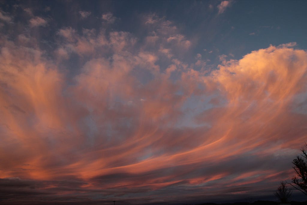 Sun reflecting in whispy clouds in afternoon sky