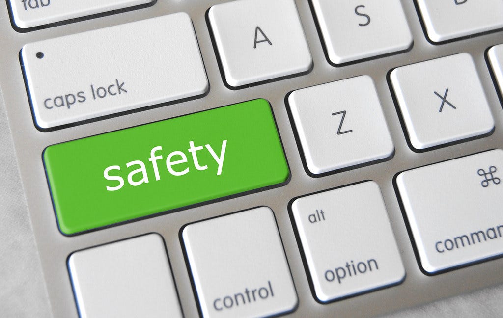 Close up image of the corner of a metal keyboard with the shift button replaced with a green button that says the word “safety”