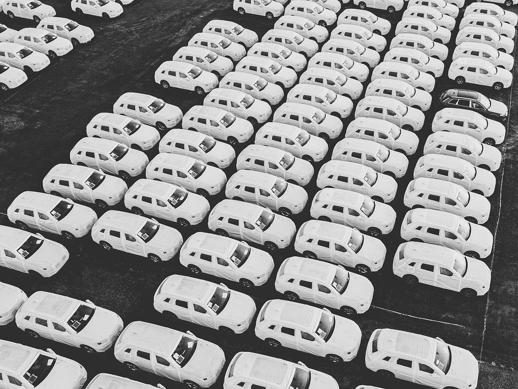 Foto vista de cima do estacionamento cheio de carros novos de uma montadora.