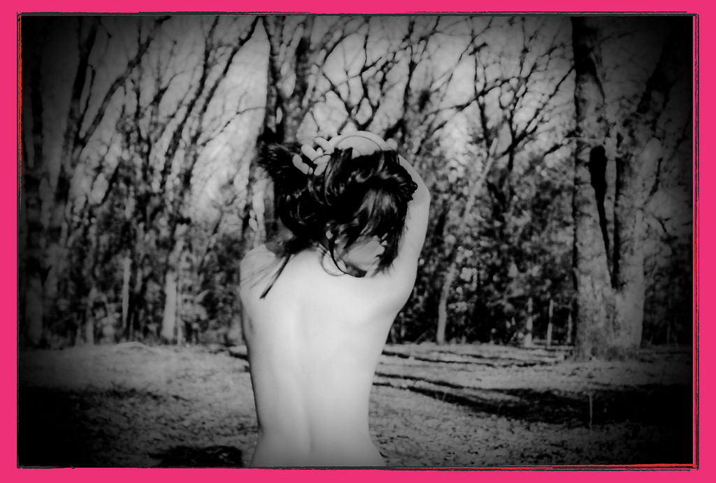 A topless woman in the woods