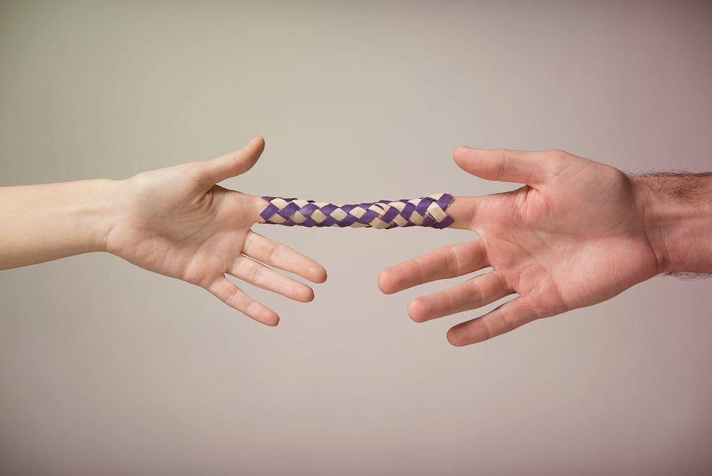 Two hands locked in a Chinese Finger Trap