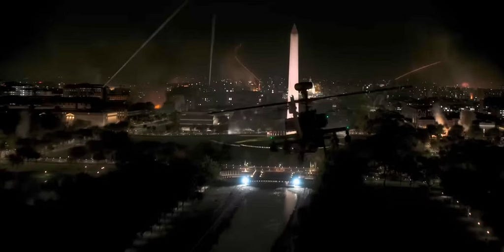 A screencap from the film showing an aerial view of Washington DC at night, engulfed in battle, with an attack helicopter in the foreground and the washington monument in the background.