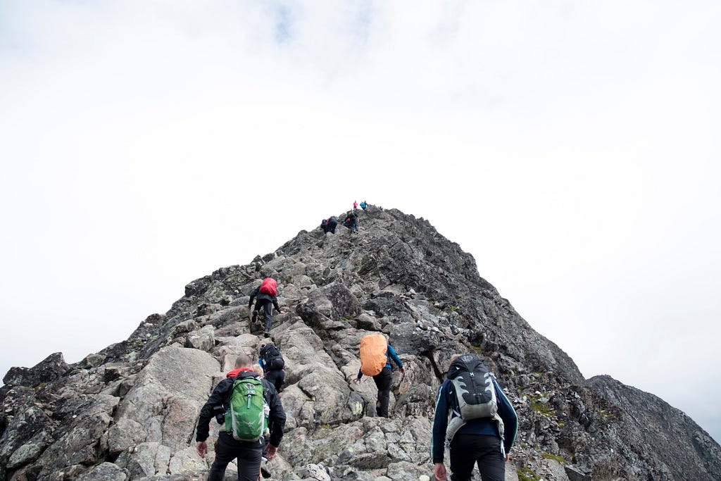 People climbing up a mountain peak