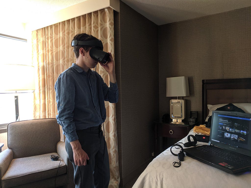 A man using a VR headset inside a hotel room.
