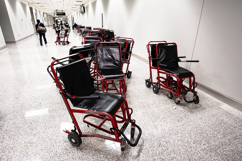 a long corridor in an airport with lots of wheelchairs in them