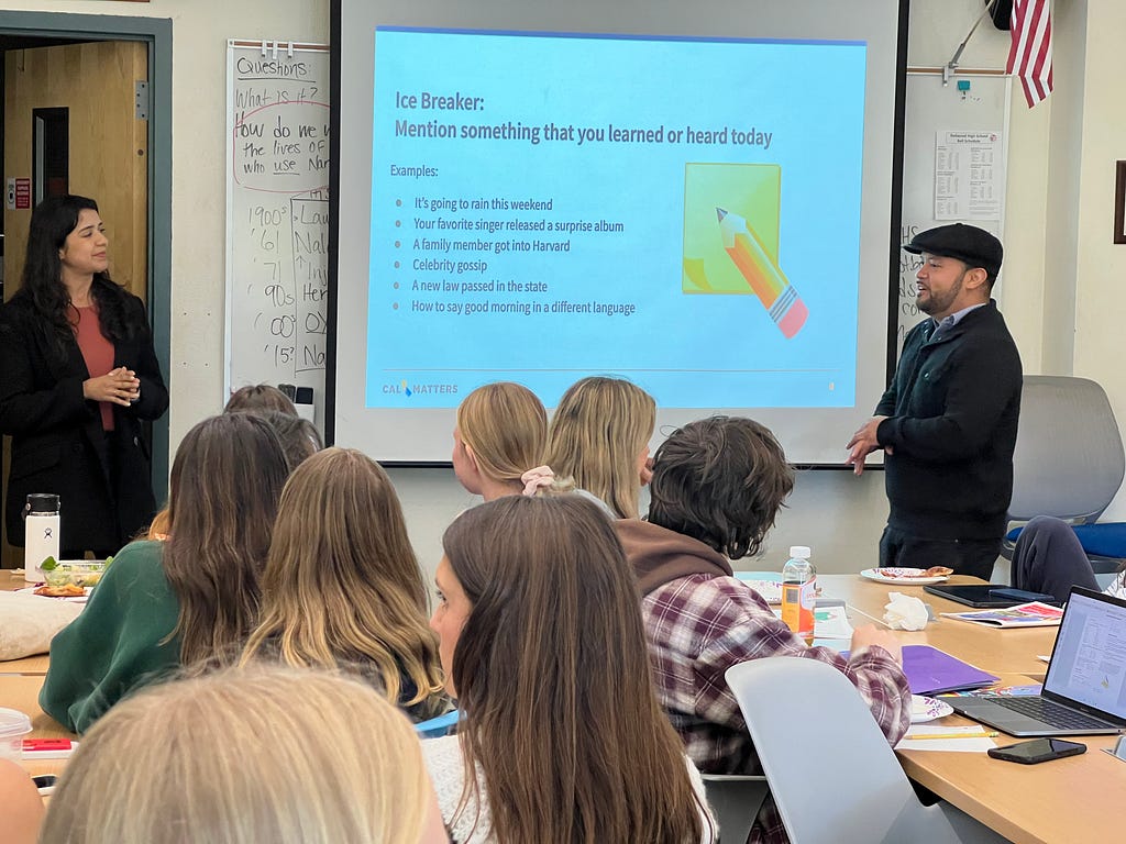 Ana Clara Otoni and Michael Lozano presenting in front of a group of high school students.