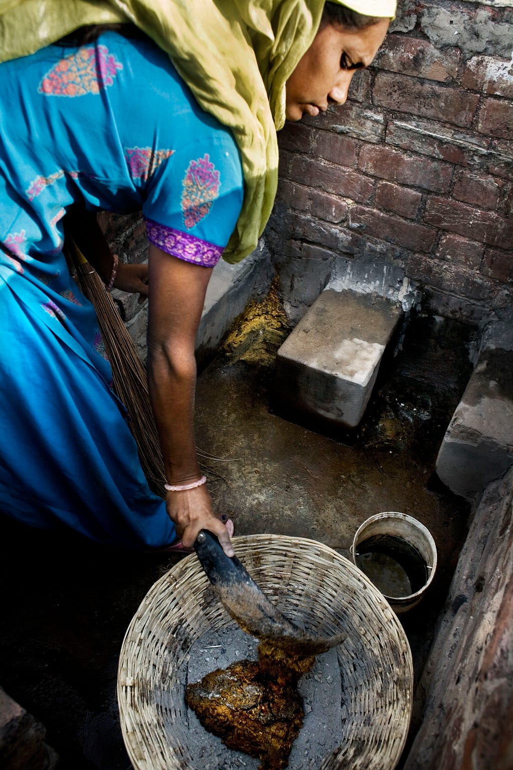 Indian woman emptying a latrine in Lucknow, Uttar Pradesh