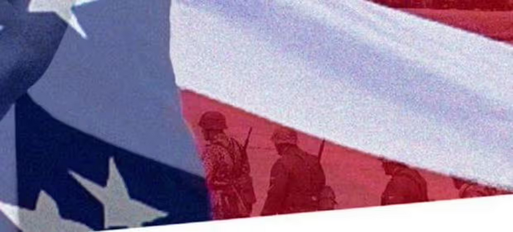 American flag with the hazy image of soldiers marching across it. According to the Guardian, “the soldiers actually have the SS eagle insignia on their arms. At least one of the troops is wearing the dot camouflage print associated with Nazis.”
