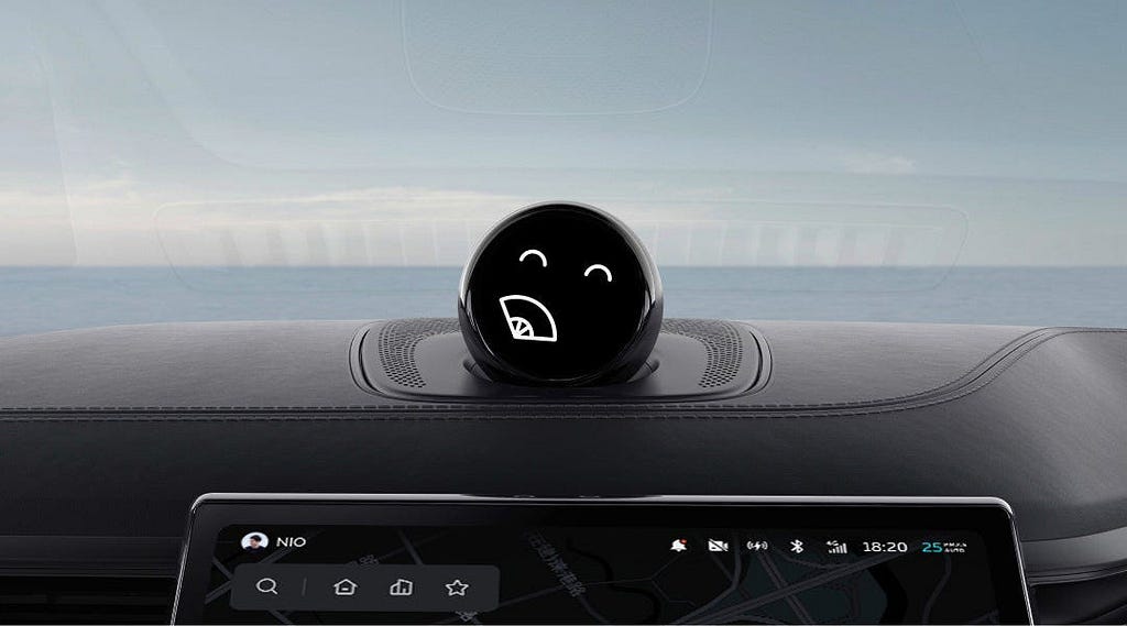 A close-up of NIO’s AI assistant, NOMI, displayed as a black circular device with a smiling face on the car dashboard