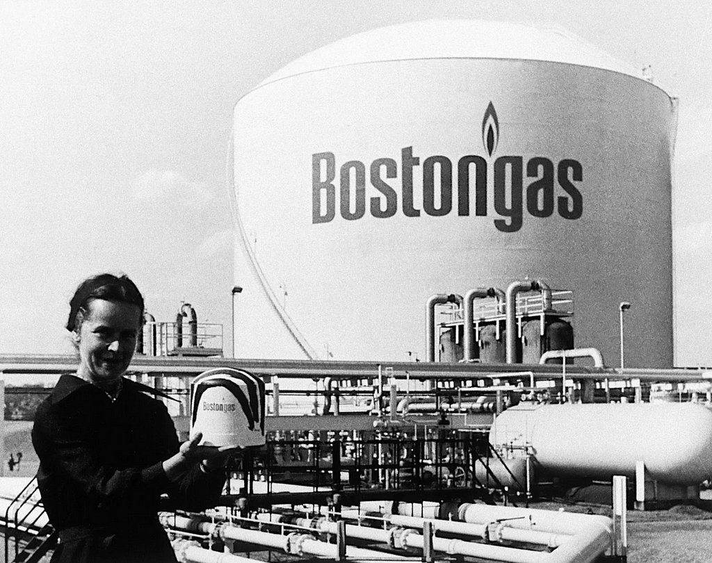 Photography of Corita and her famous canvas, the Boston Gas Tank.