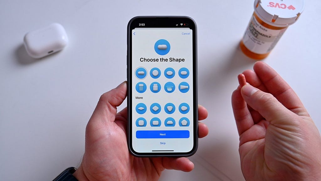 Person holding phone and pill adding them to the tracker app