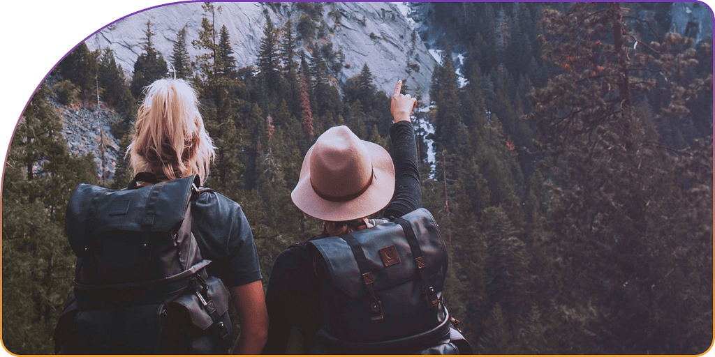 2 hikers on a mountain pointing to a direction