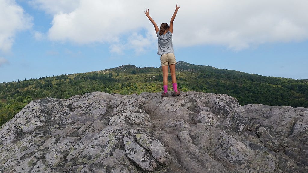 kid toasts to their summit view