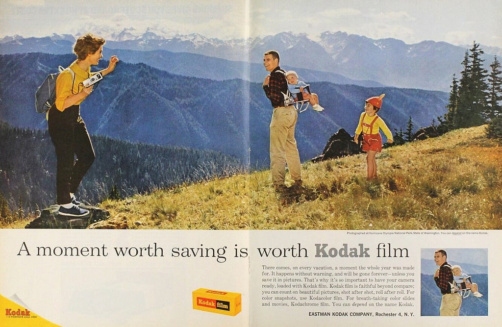 A vintage two-page spread Kodak ad with a large photo of a family hiking and the tag line ‘A moment worth saving is worth Kodak film’