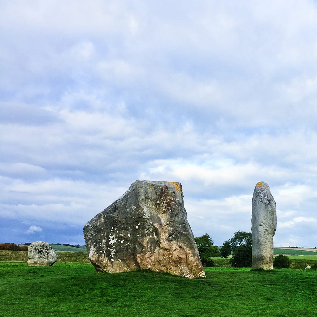 Large ancient stone circle, green grass and cloudy sky