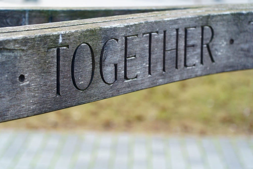 The word TOGETHER carved in a wooden beam.